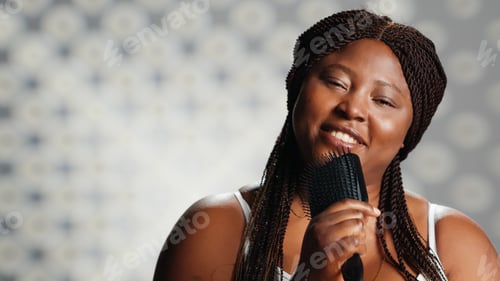 Preview: Young woman singing with hair brush in studio