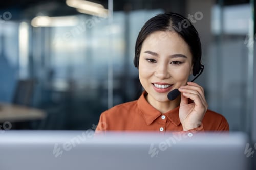 Preview: Friendly businesswoman using headset in modern office