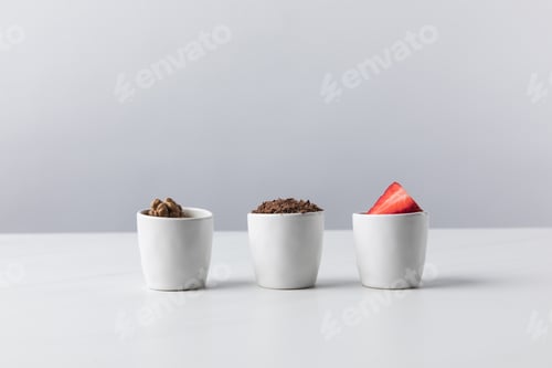 Preview: Front view of three bowls with walnuts, grated chocolate and strawberries