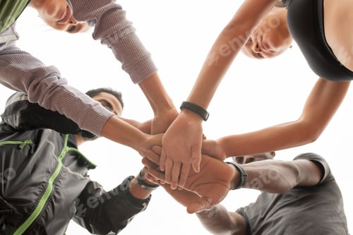 Preview: Below angle of young intercultural sporty people maing pile of hands