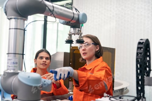 Preview: Female Engineer check and control automation robot arms machine in factory. robotics manufacturing.