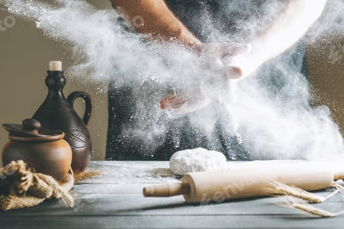 Preview: Male hands with flour clap over the dough next to clay pot and a bottle and rolling pin