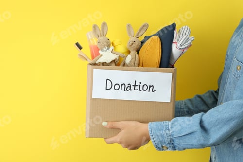 Preview: Woman holds donation box on yellow background