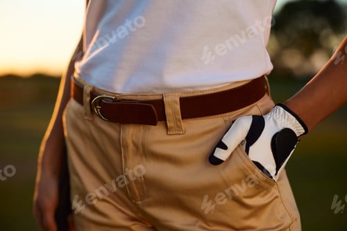 Preview: Close up of female golfer with hand in her pocket on a golf course.