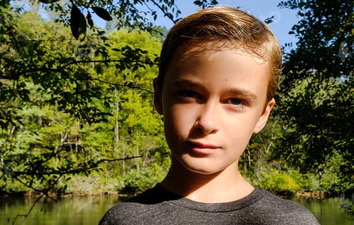 Preview: Generation z kid in the woods lakeside with a face of psychology on vacation thinking next steps.