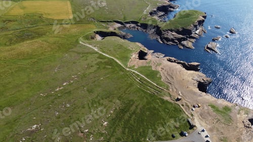 Preview: Aerial view of coastal cliffs and green fields.