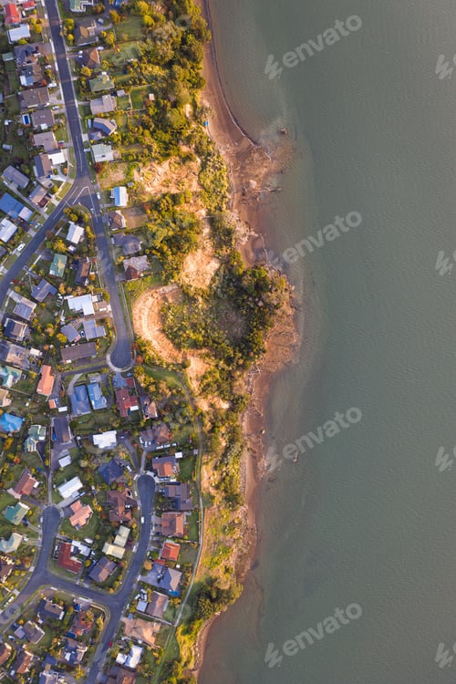Preview: Aerial top view of a seascape against a shore covered with houses in New Zealand