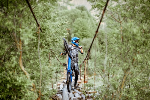 Preview: Cyclist riding on the old bridge in the mountains