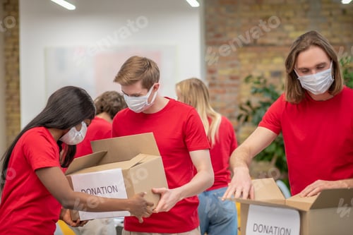 Preview: Young volunteers in red tshirts at work in a distribution point