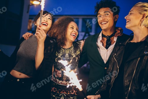 Preview: Young man and women in city at night with fireworks