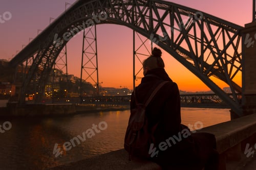 Preview: Woman looking at river and city in evening
