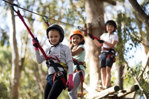 Preview: Portrait of happy kids crossing zip line