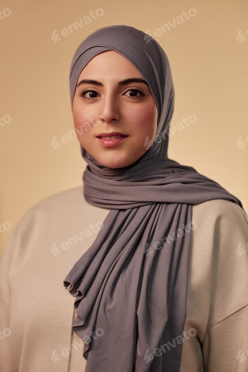 Preview: Young beautiful Muslim woman in grey headscarf and beige pullover