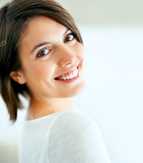 Preview: Candid and content. A beautiful woman smiling candidly at the camera - closeup.