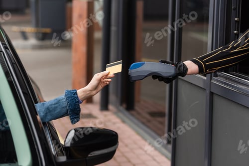 Preview: cropped view of driver with credit card near woman in latex glove with payment terminal