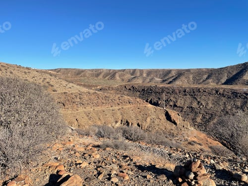 Preview: Desert landscape with rocky terrain and clear blue sky.