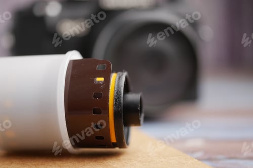 Preview: Film roll and camera on a wooden surface with soft focus