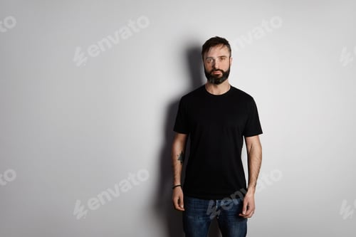 Preview: Portrait of bearded man in black tshirt on the empty background
