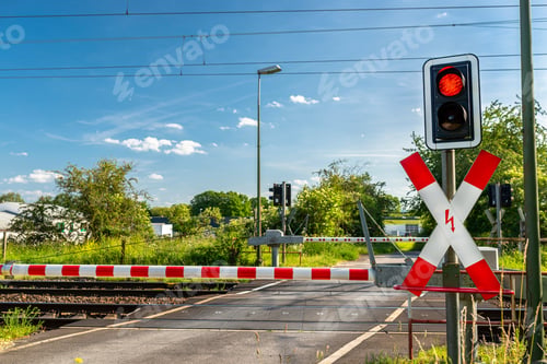 Preview: Guarded railroad crossing with closed barriers, red warning light and cross of Saint Andrew.closed