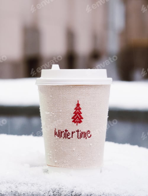Preview: A Winter time coffee cup stand outside on a cold winter snowy day, no people, front view.