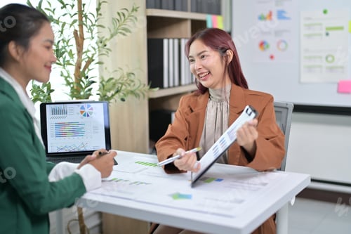 Preview: Business Meeting with Colleagues Discussing Financial Reports in Modern Office Setting