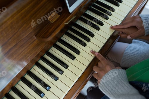 Preview: Mother assisting daughter in playing piano at home