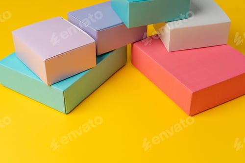 Preview: Colorful cardboard boxes on yellow background, copy space