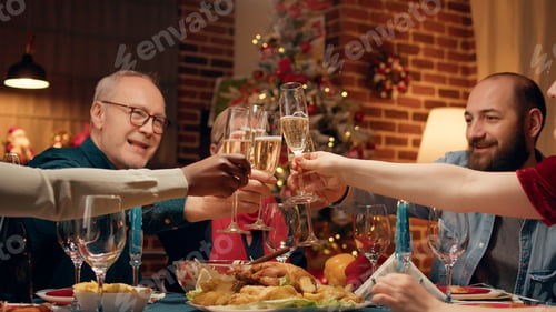 Preview: Happy family toasting sparkling wine at Christmas dinner table in living room