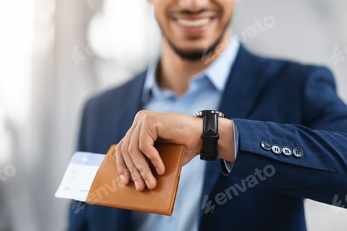 Preview: Smiling Man Holding Passport With Tickets And Looking At Wristwatch, Closeup Shot