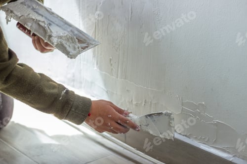 Preview: Construction worker applying plaster on wall with spatula