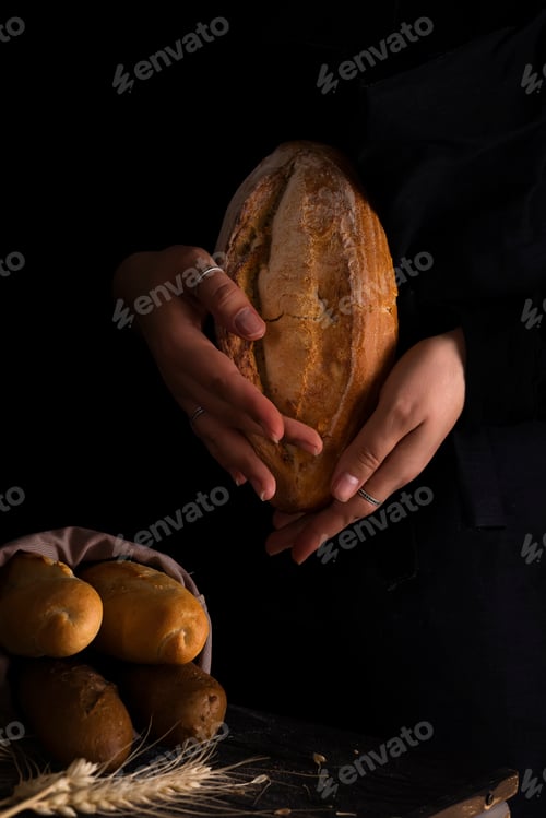 Preview: Baker woman holding rustic organic loaf of bread in hands - rural baker