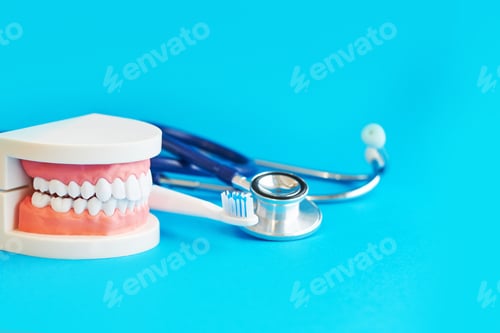 Preview: White teeth model and stakescope on blue background. teeth care.