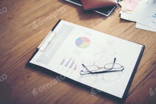 Preview: Office desk workplace with business Report charts on wooden table.