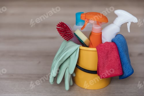 Preview: Various house cleaning products and accessories in a bucket on the floor