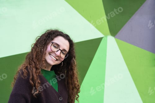 Preview: Young woman smiling with green and grey geometric background