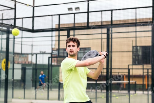 Preview: man playing paddle tennis. backhand