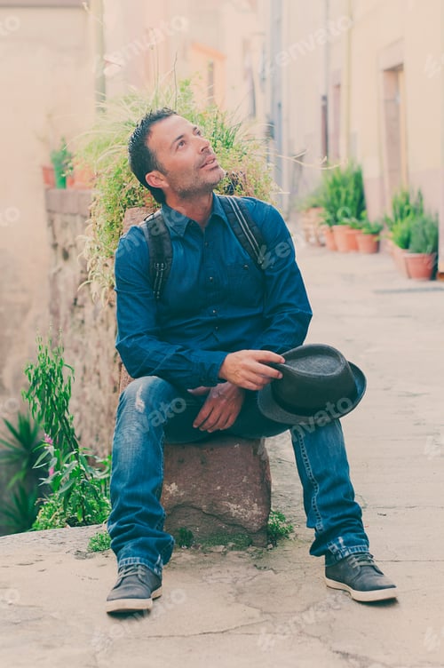 Preview: Tourist man sitting in the city center during his trip in italy