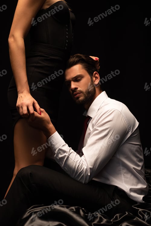 Preview: sexy couple of lovers sitting on bed in dark room