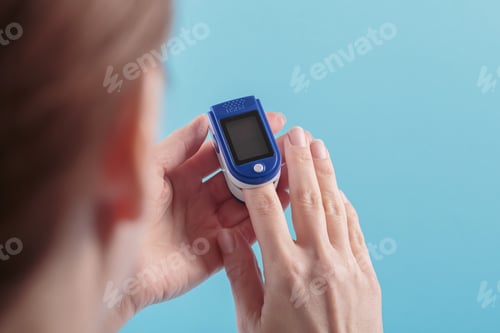 Preview: Woman self testing for blood oxygen levels from pulse oximeter