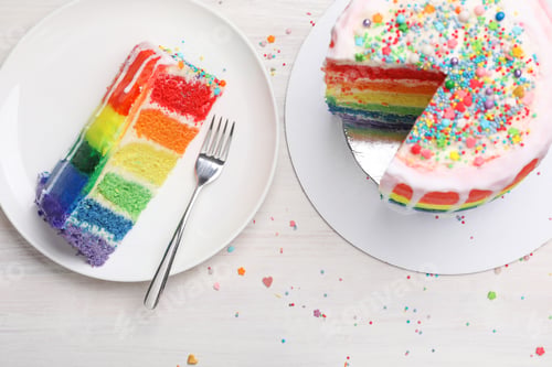 Preview: Delicious rainbow cake served on light wooden table, flat lay