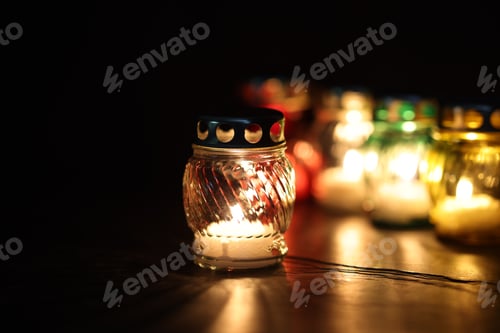 Preview: Many grave candles on black background, closeup. Space for text