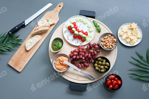 Preview: Charcuterie board shot from above. Fruits, cheese, pesto and humus. Olives and cucumbers.