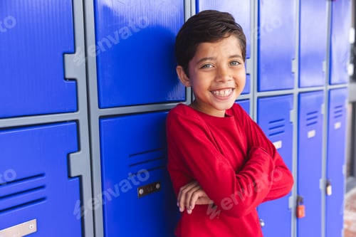 Preview: In school, outdoors, young biracial male student is standing, smiling