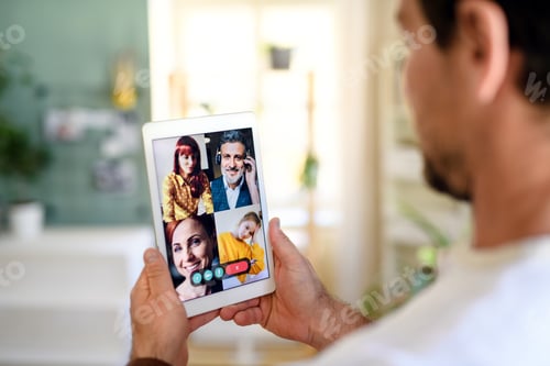 Preview: Unrecognizable man having video call on tablet at home