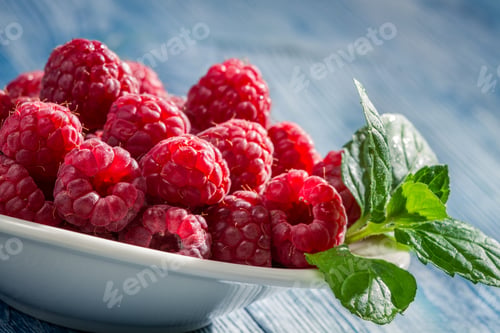 Preview: Closeup of fresh raspberries with green leaf