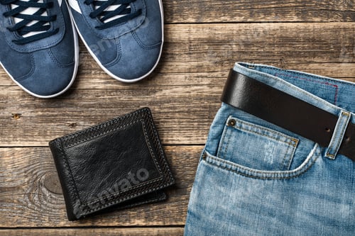 Preview: Blue Jeans with belt, shoes and leather wallet on wooden background