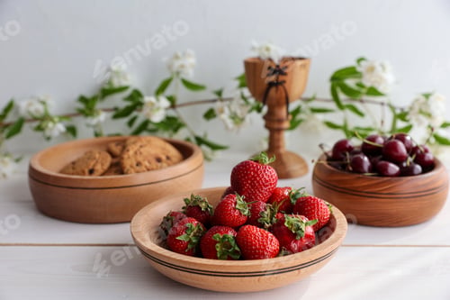 Preview: Fresh strawberries, cherries and biscuits in wooden dishes on a light wooden background