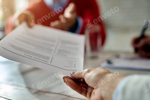 Preview: Close-up of a candidate giving his CV while applying for a job.