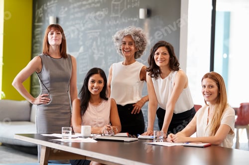Preview: Five female colleagues at a work meeting smiling to camera