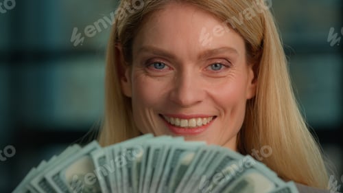 Preview: Caucasian rich middle-aged adult woman close up headshot female face with banknotes fan of money